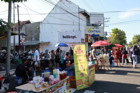 Foto de Kudus, diciembre de 2022. Foto de vendedores de alimentos y bebidas a un lado de la carretera vendiendo a una multitud de visitantes y compradores en la plaza principal de la ciudad de Kudus. - Imagen libre de derechos