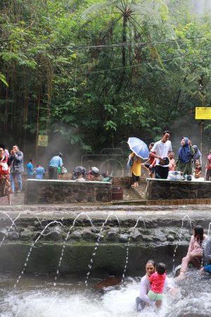 Téléchargez les photos : Tegal, janvier 2023. Photo de visiteurs occupés se détendre et profiter du bain de source chaude Guci. - en image libre de droit