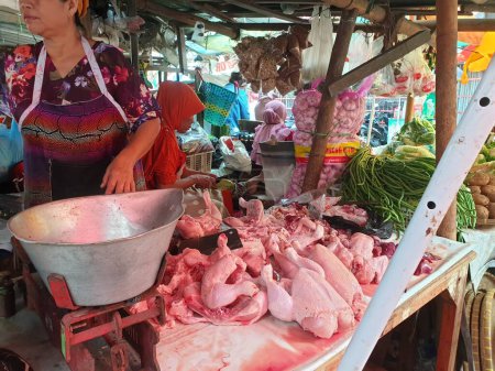 Téléchargez les photos : Tegal, mai 2023. Portrait photo d'un vendeur de poulet sur le marché découpant des poulets à offrir aux clients. - en image libre de droit