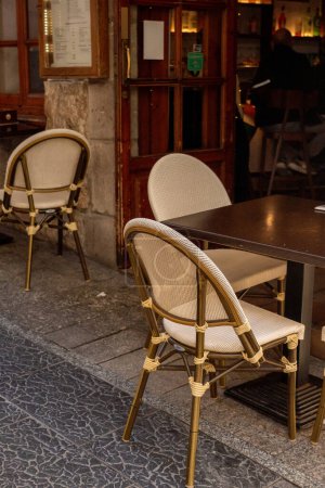 Téléchargez les photos : Empty beige chairs and brown tables on the street of mediterranean city, details of the outdoor restaurant. - en image libre de droit
