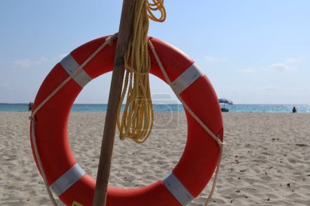 Téléchargez les photos : Bouée de sauvetage rouge sur la plage - en image libre de droit