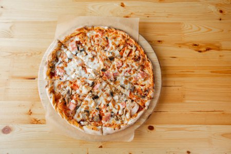 Téléchargez les photos : Gros plan main de chef boulanger en uniforme tablier bleu coupe pizza à la cuisine. Photo de haute qualité - en image libre de droit