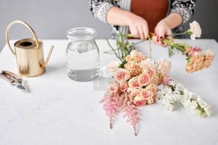 Téléchargez les photos : Installation étape par étape des fleurs dans un vase. Bouquet de fleurs, prêt pour la maison. Fleurs fraîches coupées pour la maison de décoration. Fleuriste européen. Livraison fleur fraîche coupée - en image libre de droit