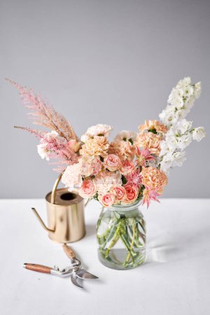 Téléchargez les photos : Arrangement de fleurs finies dans un vase pour la maison. Bouquet de fleurs, prêt pour l'intérieur. Fleurs fraîches coupées pour la maison de décoration. Fleuriste européen. Livraison fleur fraîche coupée - en image libre de droit