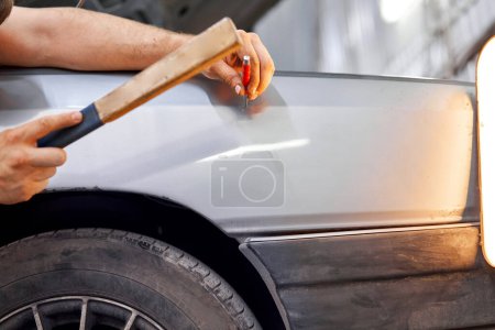 Removing dents on the car. PDR technology. Car body repair without painting