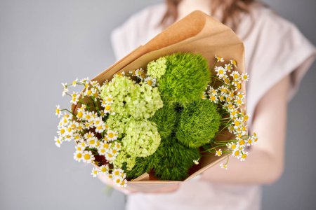 Photo for Small Beautiful bouquets of mixed flowers in woman hand. Floral shop concept . Beautiful fresh cut bouquet. Flowers delivery. High quality photo - Royalty Free Image