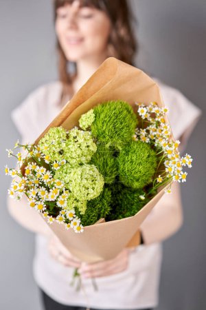 Photo for Small Beautiful bouquets of mixed flowers in woman hand. Floral shop concept . Beautiful fresh cut bouquet. Flowers delivery. High quality photo - Royalty Free Image