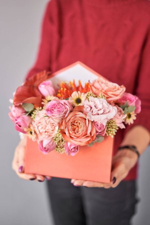 Photo for Box in the form of an post envelope of a letter. Small Beautiful bouquets of mixed flowers in woman hand. Floral shop concept . Beautiful fresh cut bouquet. Flowers delivery. High quality photo - Royalty Free Image