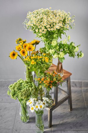 Photo for A colorful display of yellow and white flowers, consisting of herbaceous plants and annual flowers, adorns the tabletop - Royalty Free Image