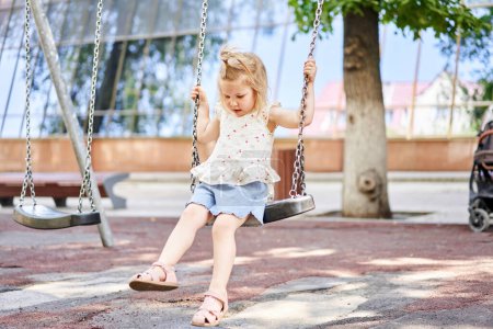 Photo for Active little child playing on climbing net and jumping on trampoline at school yard playground. Kids play and climb outdoors on sunny summer day. Cute girl on nest swing at preschool sport center - Royalty Free Image