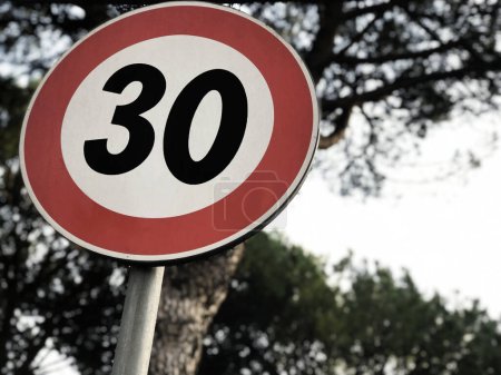 Téléchargez les photos : Speed limit sign 30 kmh with trees and sky background - en image libre de droit