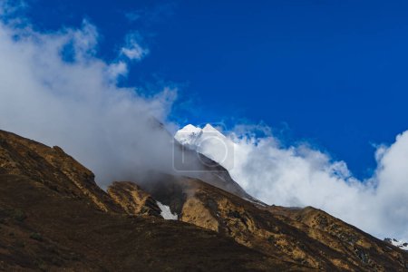 Majestätische Bergkette in Nepal mit wolkenverhangenem Himmel, nepalesische Bergkette unter strahlend blauem Himmel