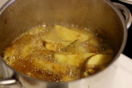 Téléchargez les photos : Embarquez pour un voyage culinaire alors que nous dévoilons l'art de faire frire des quartiers de pommes de terre à la perfection croustillante - en image libre de droit