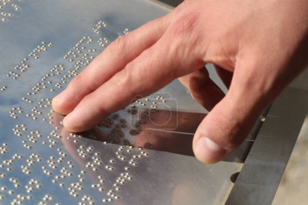 Explore el mundo de la comunicación táctil mientras las manos navegan delicadamente por los puntos elevados del lenguaje braille