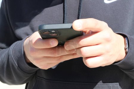 Erkunden Sie das moderne Zeitalter der Konnektivität, während die Hände geschickt durch die Oberfläche eines Smartphones navigieren. Mit den Fingern über den Touchscreen