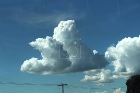 Wispy Wolken schweben anmutig über eine riesige Weite des klaren blauen Himmels und malen eine malerische Szene der Ruhe und Gelassenheit