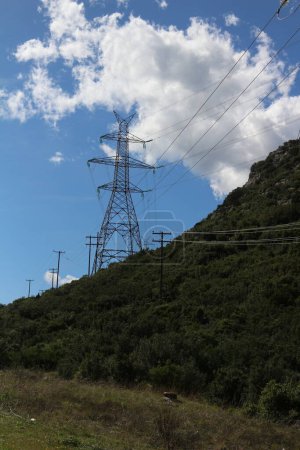 Towering electric structures dot the landscape, their imposing presence symbolizing the intricate network that powers modern civilization, evoking a sense of awe and wonder