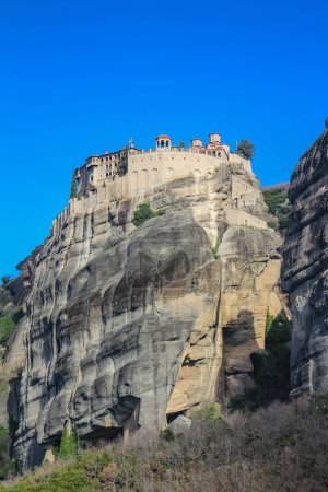 Experience the awe-inspiring beauty of the church nestled atop a cliff in Meteora, Greece, a testament to human ingenuity and spiritual devotion