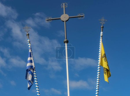 Contempla la escena serena de la bandera griega plegada, la bandera ortodoxa y una cruz reverente