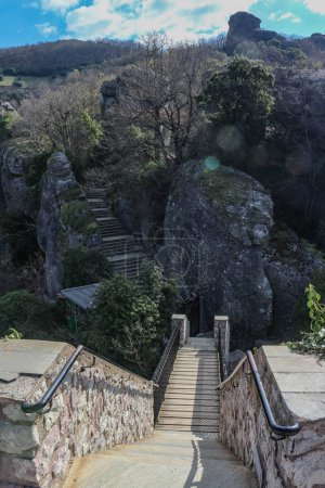 Embárcate en un viaje mágico mientras subes una encantadora escalera enclavada en medio de la impresionante naturaleza que rodea las antiguas iglesias de Meteora, Grecia