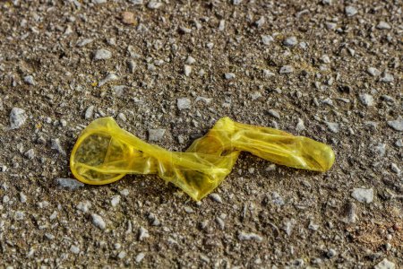 Découvrez les dures réalités de la vie urbaine avec cette image brute et troublante capturant un préservatif usagé jeté sur le trottoir.