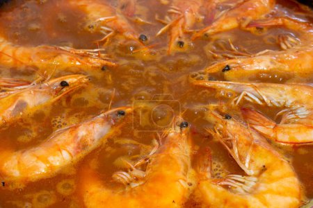 Vivez l'harmonie culinaire pendant que les crevettes dorées se joignent au vibrant mélange de saveurs de la paella espagnole traditionnelle, enrichissant chaque bouchée d'un délice salé.