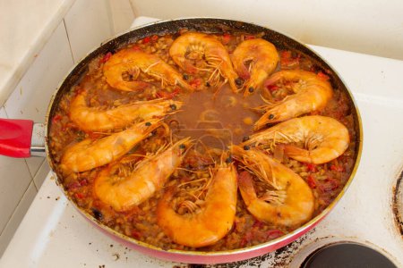 Experience culinary harmony as golden-fried shrimp rejoins the vibrant medley of flavors in the traditional Spanish paella, enriching each bite with savory delight