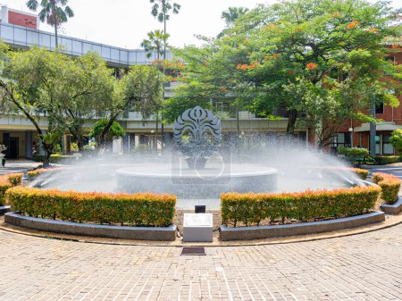 Foto de Depok, West Java, Indonesia - August 12, 2022: Large landscape view of the fountain pool garden in front of the faculty administration building, the University of Indonesia. - Imagen libre de derechos