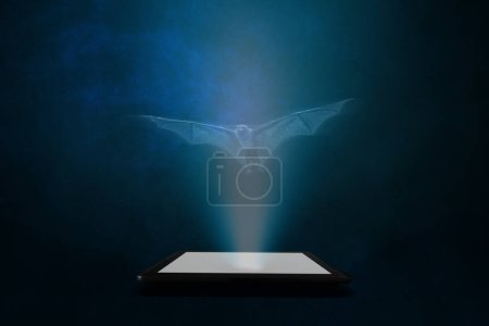 Foto de Un murciélago se proyecta desde una tableta con un fondo abstracto azul. Inteligencia artificial. - Imagen libre de derechos