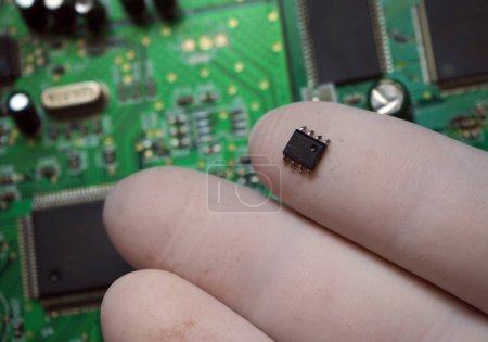 Foto de Insertar microchip en una tarjeta electrónica. Chip de montaje en superficie retirado de la placa. - Imagen libre de derechos