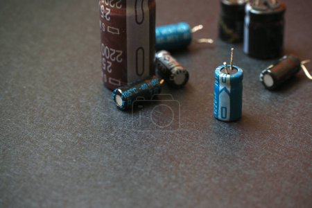 Téléchargez les photos : Condensateurs électrolytiques à trou traversant isolés sur un fond noir. - en image libre de droit