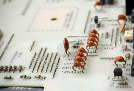Téléchargez les photos : Gros plan des composants électroniques sur une carte de circuit imprimé. Concentré sur les condensateurs à disques en céramique. - en image libre de droit