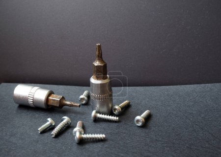 Photo for Ti type allen screws and allen screwdrivers isolated on black background. Focused on upright screwdriver. - Royalty Free Image
