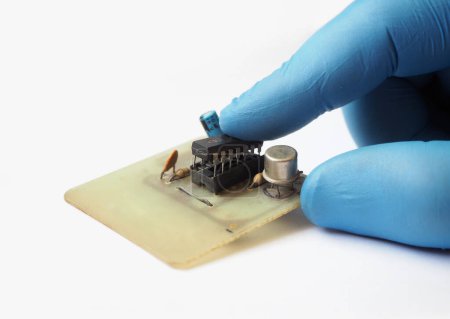 Téléchargez les photos : Le technicien branche un circuit intégré dans la prise. Circuit intégré sur carte électronique simple. - en image libre de droit