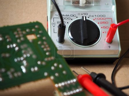 Foto de Placa de circuito electrónico con multímetro. Centrado en el conmutador ohmímetro. - Imagen libre de derechos