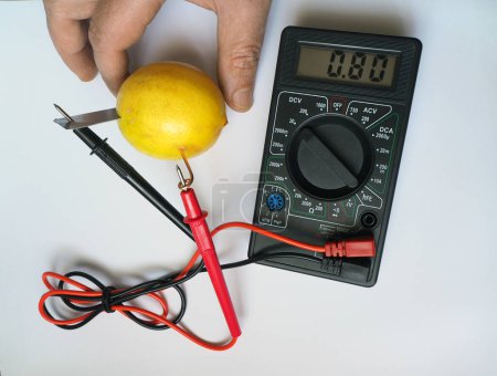 Photo for Lemon and electricity experiment. Generating and measuring electricity from lemon. Electrical voltage at millivolts levels. Bio battery. - Royalty Free Image