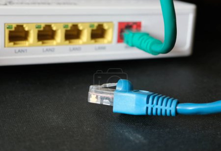 Foto de Cables con el conector RJ45 delante del dispositivo de red. Concepto de comunicación. Enfoque seleccionado. - Imagen libre de derechos