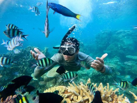 Unterwasseraufnahmen eines jungen Mannes beim Schnorcheln in einem tropischen Meer