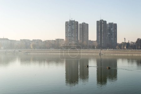 Ein Panoramablick auf die Gebäude an der Donau. Gebäude an der Donau im Winter, von der Sonne erleuchtet.