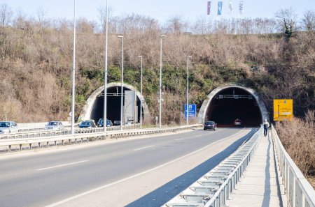 Novi Sad, Serbia. March - 16. 2021. Tunnel on the end of the Liberty bridge with cars and road signs under the part of Fruska gora mountain. Editorial image.