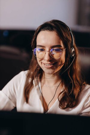 Photo for Portrait of hotline operator girl talking to client. Happy young woman working in call center. Beautiful lady as a customer support agent. High quality photo - Royalty Free Image