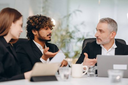 Photo for Diverse business team discussing new strategy in office. Selective focus of businesspeople at the conference table. High quality photo - Royalty Free Image