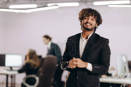 Photo for Ambitious entrepreneur laughing at camera. Indoor shot of handsome young businessman in office. Corporate manager man expressing positive emotions. High quality photo - Royalty Free Image