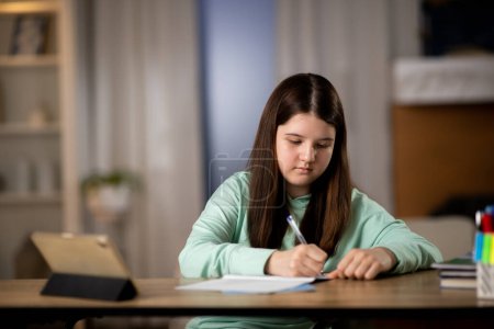 Foto de Niña haciendo la tarea con la tableta digital. Estudiante de primaria que estudia en línea. Foto de alta calidad - Imagen libre de derechos