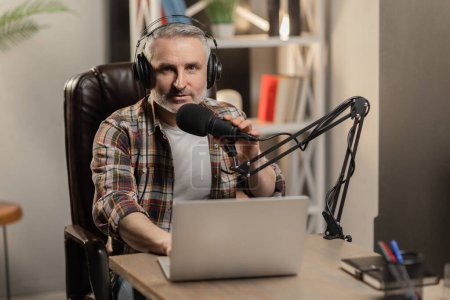Photo for Radio worker is talking to microphone. Senior man in casual shirt is doing podcast. High quality photo - Royalty Free Image