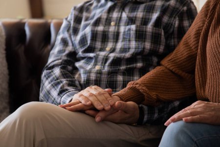 Téléchargez les photos : Senior homme émotionnellement soutenir et réconforter sa femme aînée tout en lui tenant la main. Photo de haute qualité - en image libre de droit