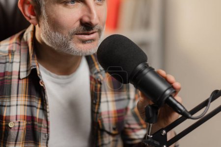 Photo for Cropped view of a gray-haired man who is sitting in front of a studio microphone. The announcer broadcasts on the radio station. High quality photo - Royalty Free Image