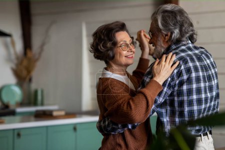 Téléchargez les photos : Heureux couple âgé rit et danse dans la cuisine le jour de leur anniversaire. Photo de haute qualité - en image libre de droit