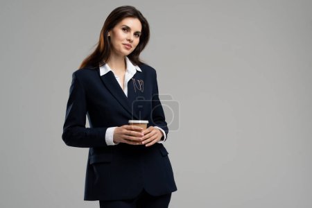 Photo for Portrait of cute successful entrepreneur young lady holding hot paper cup coffee waiting her colleagues. Beautiful project manager woman drink tea. High quality photo - Royalty Free Image