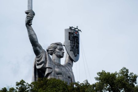 Foto de Kiev, Ucrania - 11 de agosto de 2023: Patria o Madre Ucrania monumento. nuevo tridente reemplazado, símbolo nacional ucraniano, escudo de armas, que se instaló en lugar del escudo de armas de la Unión Soviética - Imagen libre de derechos